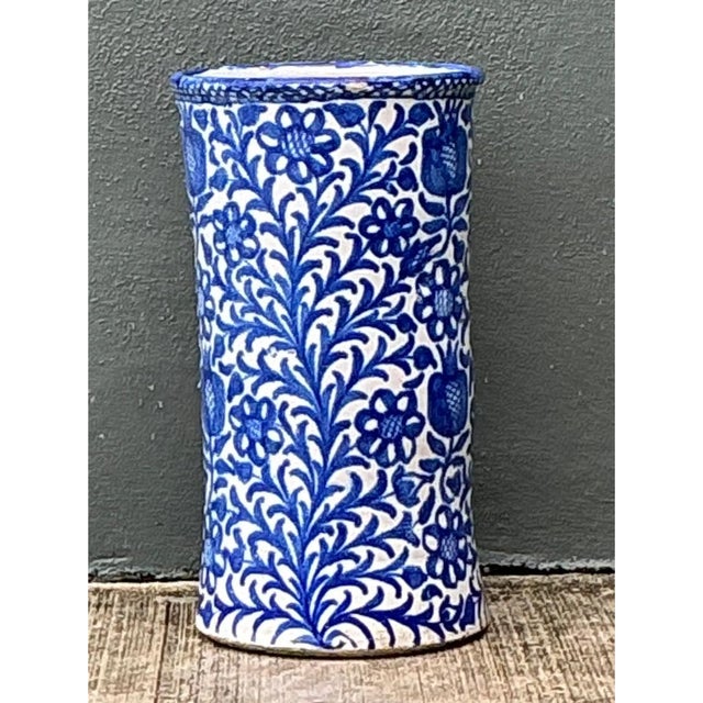 This vintage ceramic umbrella stand is densely decorated in a classic blue-and-white floral motif, with climbing vines of...
