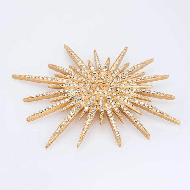 Vintage Chanel Large Starburst crystal brooch (circa 2001) crafted in yellow gold tone. Small crystals are set into the...