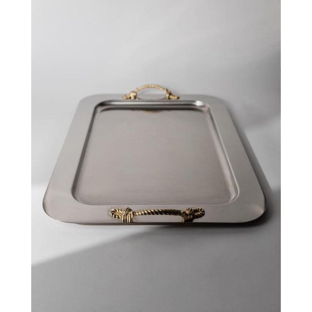 This vintage stainless steel tray from 1980s Italy is a refined Inoxpran design, featuring elegant golden rope handles...