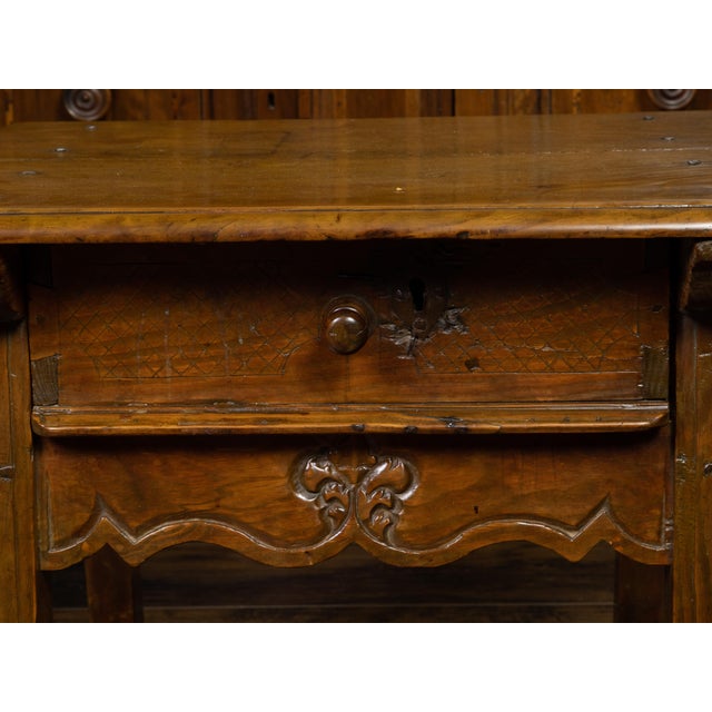 An English Georgian period oak low side table from the early 19th century, with single drawer and scalloped apron. Created...