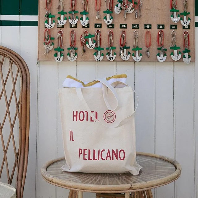 Tote Sz: 16"H x 15"W Handle Sz: 12"H Made in UK The must-have Pellicano natural cotton canvas shopping bag. Portrait in...