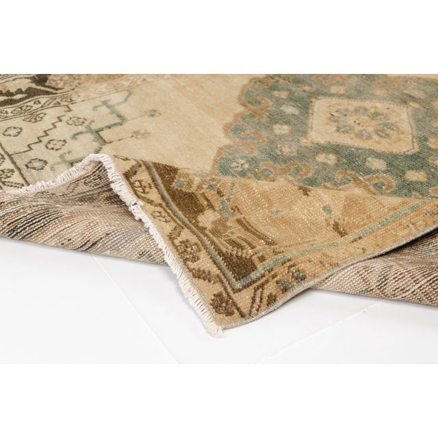 This is a vintage Turkish Oushak rug from the Mid 20th Century. The piece was hand-knotted.