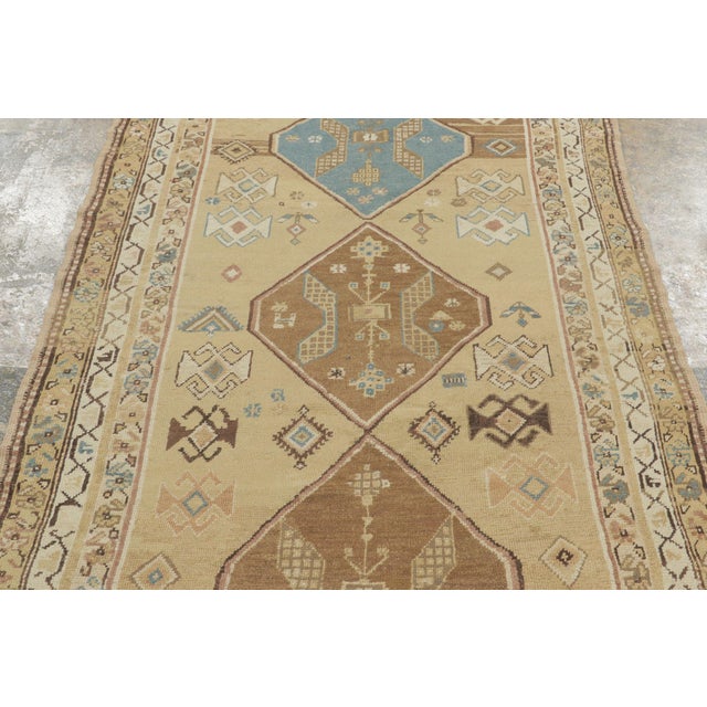 This antique 4x10 Persian Kurdish runner rug is a striking early 20th-century tribal weaving distinguished by its bold...