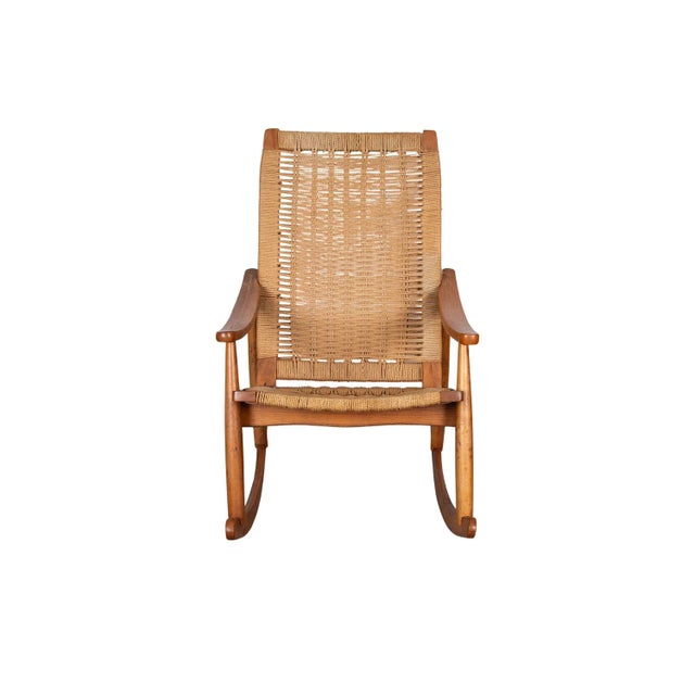 Mid-Century Modern woven rope rocking chair in the style of Hans Wegner. Features stylish roped back and seat, stretched...