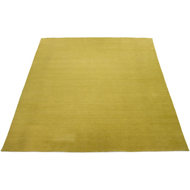 This handcrafted custom wool rug, designed in the Gabbeh style, features a solid green design. It is part of our Desert...