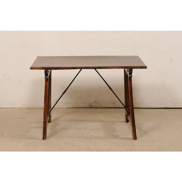 A Spanish carved-walnut stretcher table from the 19th century. This antique table from Spain features a rectangular-shaped...