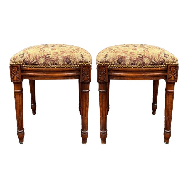 This is a pair of French style carved fruitwood ottomans or stools in leopard needlepoint. They date to the later part of...