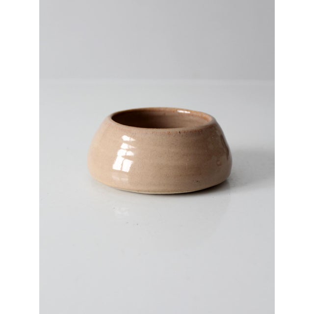 Vintage handmade studio pottery bowl showcasing a softly rounded low-profile form with a warm oatmeal glaze and...