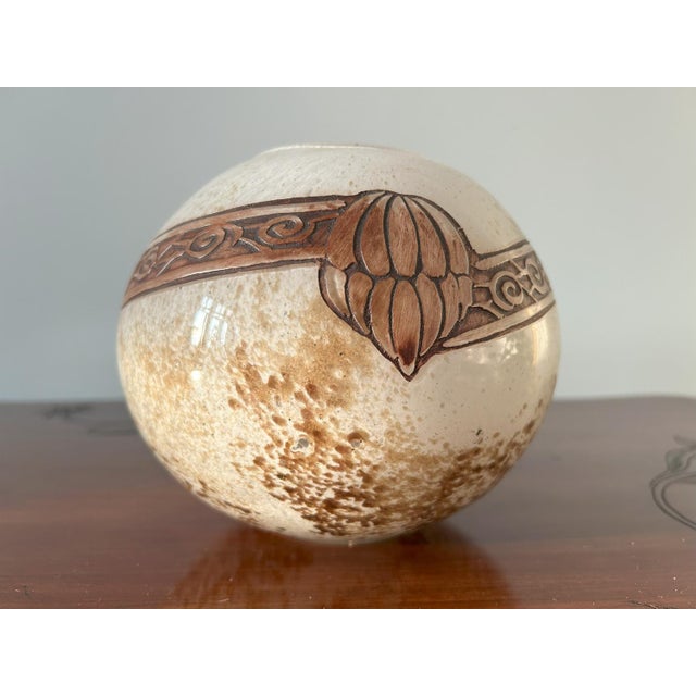 Glass vase of spherical shape with an outer layer of clear glass and a white and brown marbled bottom. The decoration is...