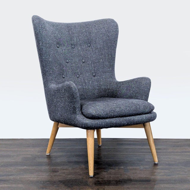 This West Elm lounge chair features a modern high-back design with button-tufted detailing and comfortable armrests. The...