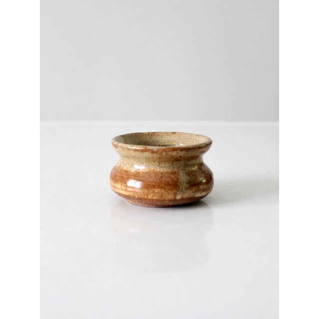 Vintage studio pottery vase dated 1983, featuring a charming hand-crafted form with a richly speckled brown glaze. The...