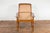 An antique Dutch Colonial Indonesian cane and wood plantation chair from the 20th century with serpentine arms and turned...