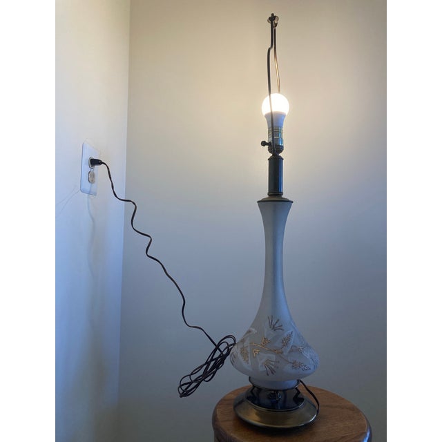 Vintage mid century modern table lamp. Painted glass table lamp, featuring a gold floral pattern with brass leg accents on...