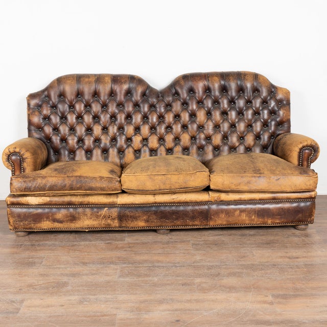Mid 20th century vintage brown leather three seat Chesterfield sofa. Upholstered in brown vintage leather, the sofa...