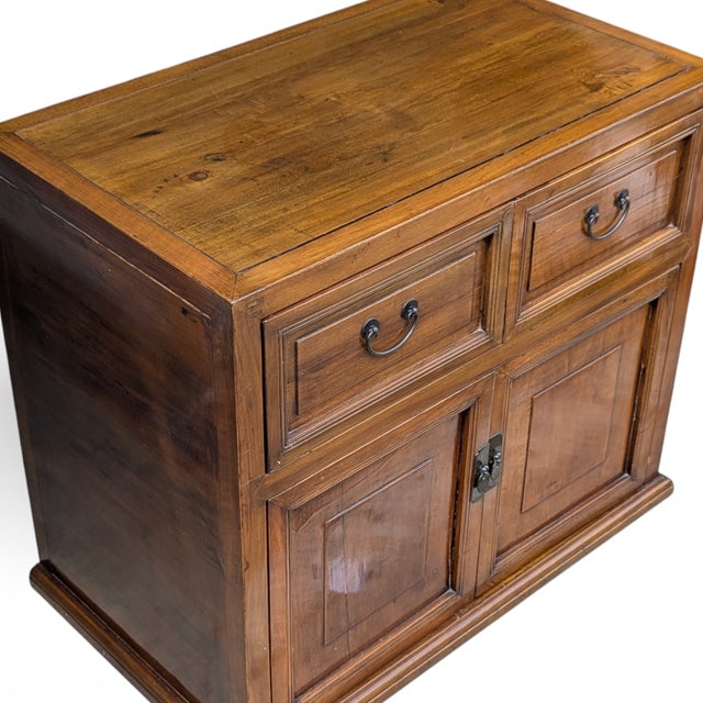 Solid elm cabinet with warm amber patina, raised panel molding, iron bail pulls, and butterfly door clasp. Two side-by-...