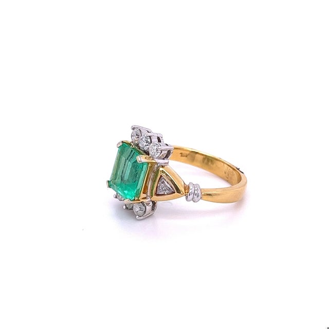 2.77-carat Emerald-cut Colombian Emerald mounted in 18k Vintage yellow gold ring setting with trillion-cut diamond...