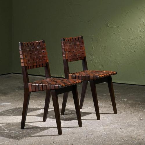 Pair of dining chairs by Jens Risom, made in the 1940s–1950s, features a frame in dark-stained solid oak with brass nails....