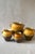 An antique French confit jar in glazed earthenware, dipped halfway in a warm ochre glaze over a bare terracotta base, with...