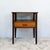 Constructed with teak veneer top and drawer front over a frame structure. Four tapered legs in darker stained wood support...