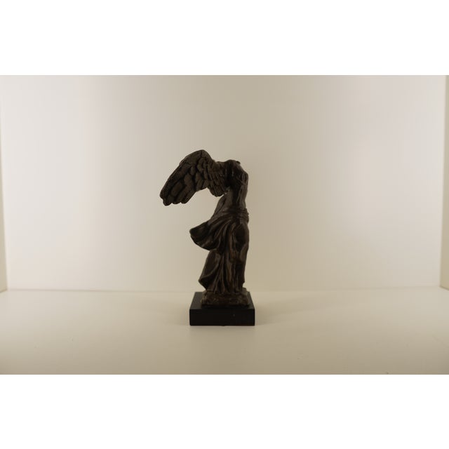 This vintage bronze sculpture depicts the iconic Winged Victory of Samothrace, the celebrated Hellenistic figure known for...