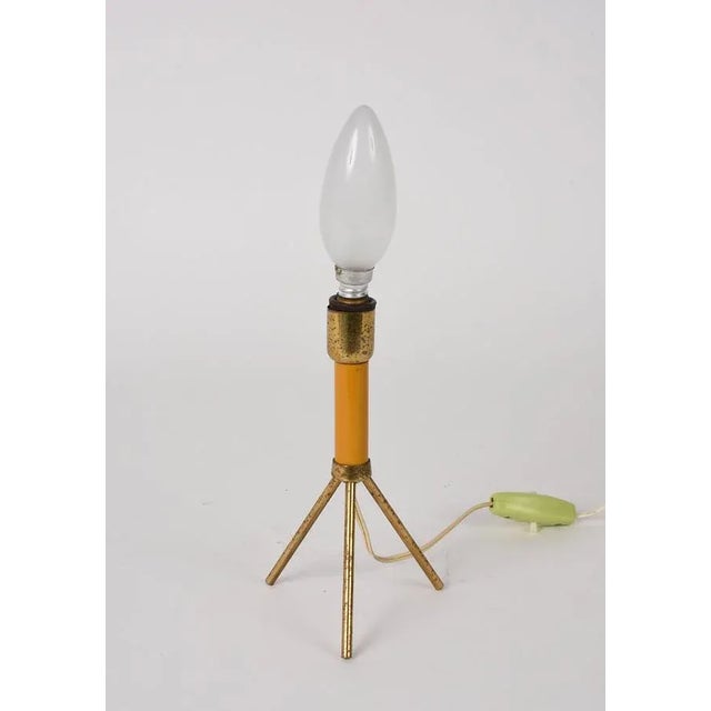 mid-century brass and lacquered metal tripod table lamp. This fantastic item was produced in Italy during the 1950s and it...