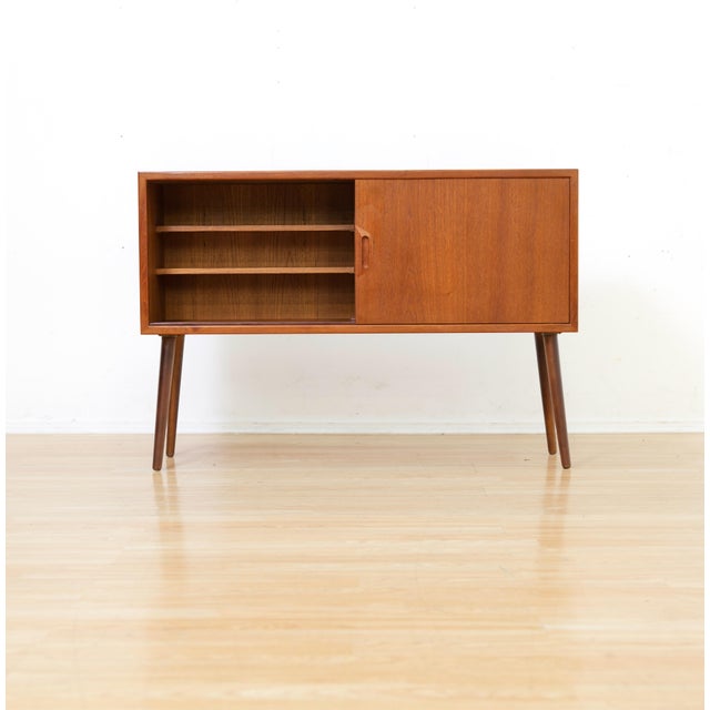 A beautifully proportioned Danish Modern cabinet crafted in teak, featuring clean lines and a warm, richly grained finish....