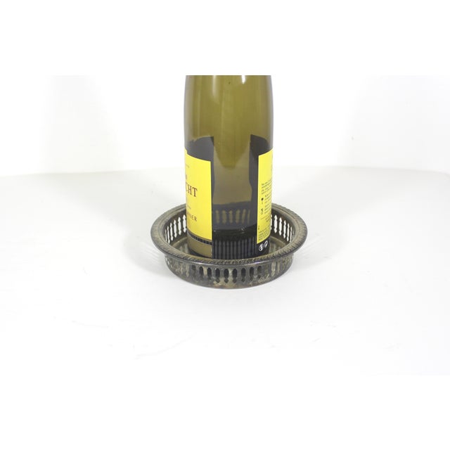 Vintage silver plated wine bottle coaster with pierced side detail and rope edge. This has tarnish and patina and spots of...