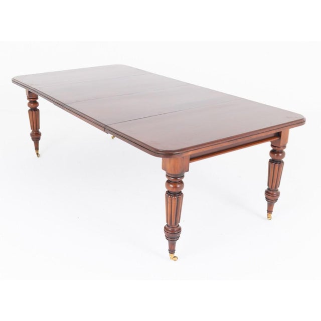 A handsome Victorian extending dining table, crafted in rich mahogany and raised upon elegant ring-turned and fluted legs,...