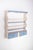 This charming plate rack, painted in white with delicate sky-blue details, combines rustic simplicity with a touch of...
