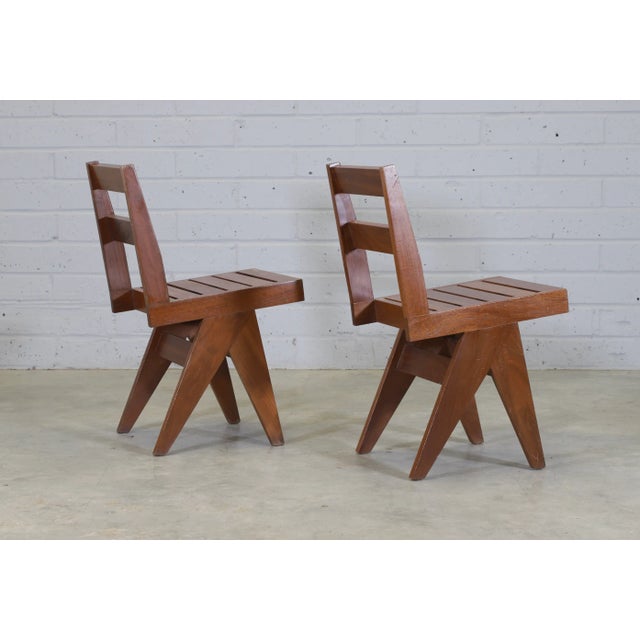 A set of 10 French, teak dining chairs, 1960’s. In the style of Pierre Jeanneret. The chairs have slightly angled, slatted...
