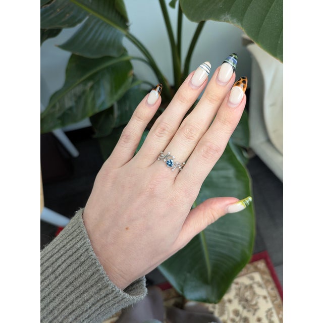 Exquisite 14k solid gold ring featuring a 5 mm trillion aquamarine center with shimmering earth-mined diamond accents for...