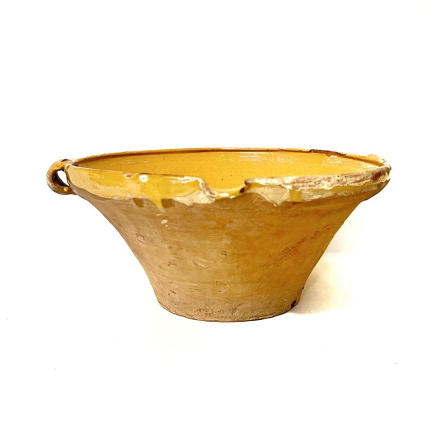 Large antique French tian terracotta bowl featuring a bright yellow or honey-colored glaze. This wide bowl has a pouring...