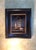 This oil painting depicts a delicate glass house containing two birds, one perched beside a nest and the other on a stone....