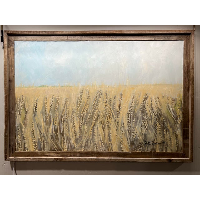 A serene, golden wheat field stretching into the distance under a soft, hazy sky. The foreground emphasizes tall, textured...