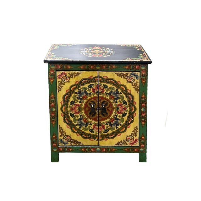 This handcrafted Tibetan-style accent cabinet features a vibrant, hand-painted aesthetic that brings an auspicious energy...
