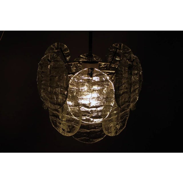 This small Kalmar pendant comprises a metal frame with 16 oval cast glass diffusers, each measuring 15 by 12 cm, and using...