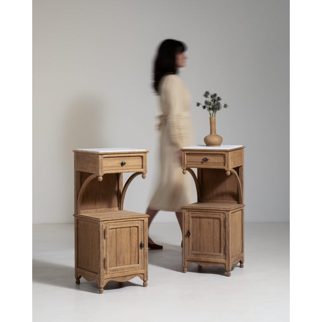 A pair of late 19th century French oak side tables with marble tops, reflecting the period's preference for combining...
