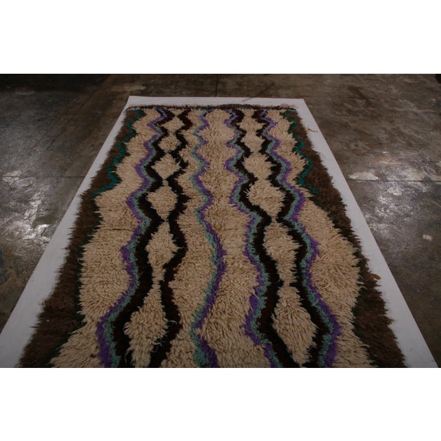 Hand knotted in Morocco between 1950-1960 with lush, high pile wool, this vintage Moroccan shag rug celebrates the classic...