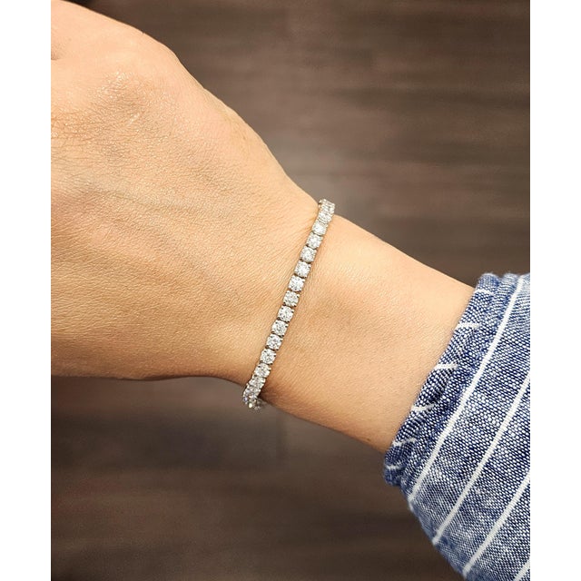 This stunning tennis bracelet exudes modern elegance. Featuring a continuous line of 50 natural round white diamonds, each...
