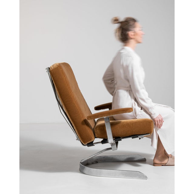 Chrome-frame swivel chair in Warm Tan Leather. Finished in warm tan leather, this chrome-frame swivel chair is...