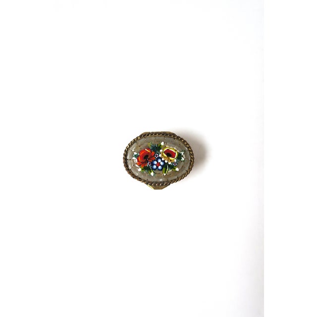 A beautiful oval Italian brass pill box with an inlayed floral glass micro mosaic millefiori design and twisted rope top...