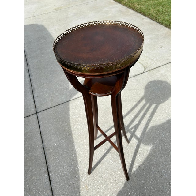 Very nice Baker plant stand . Mahogany frame four splayed legs small under shelf and decorative pierced brass gallery edge.