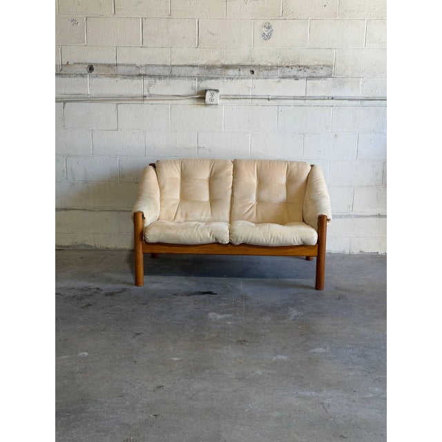 This architectural mid-size sofa features an organic open timber frame with structural cylindrical legs. Deeply stuffed...