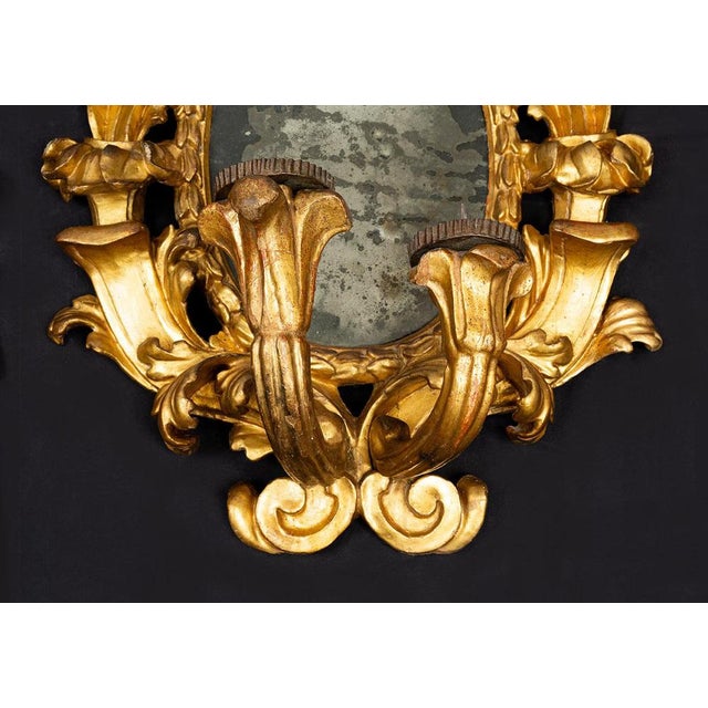 Pair of gilded, carved wooden mirrors dating from the second half of the 17th century. The central oval frame is...
