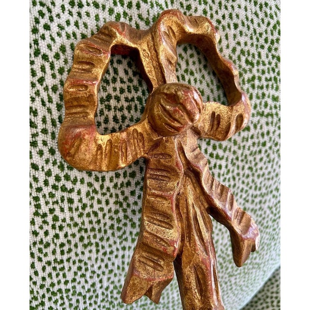 Pair of vintage Italian carved and gilded wood sconces with tassels, baskets and ribbon tied bows at top—the kind that...