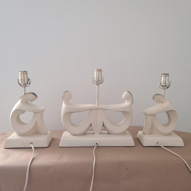 Mid Century Modern plaster table lamps of stylized seated lady in cream from the 1950's. The partial body front and hair...