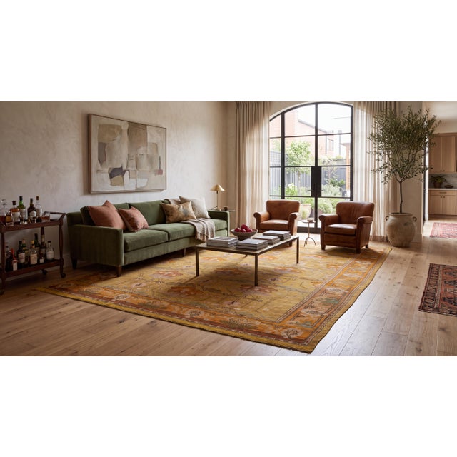 This exquisite vintage Arts and Crafts wool rug features a luminous golden-ochre field adorned with stylized, organic...