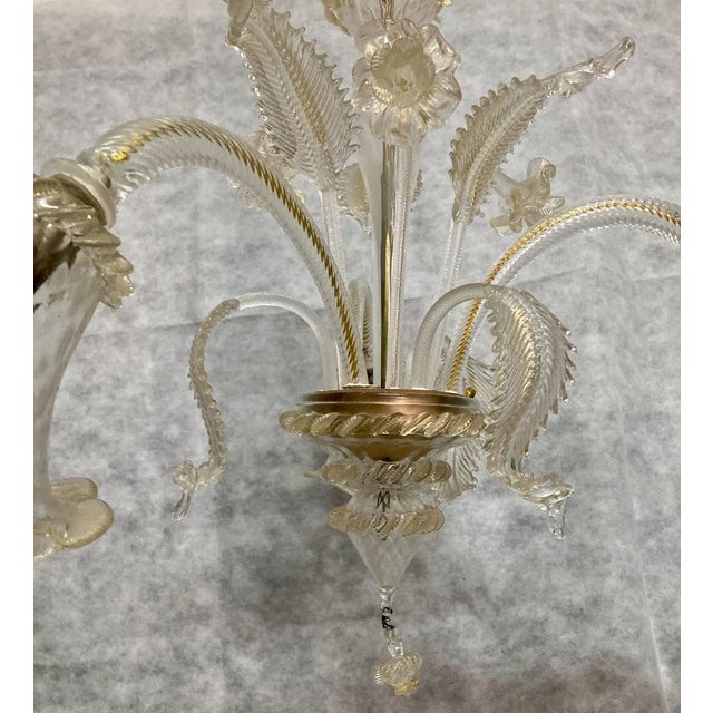 Three Murano glass chandelier; Flower -shaped lamp holder; enriched with inserts of daughters and flowers. Golden dust has...
