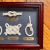 A charming and unique framed collection of five nautical knots, each labeled in Portuguese with brass-style plaques....