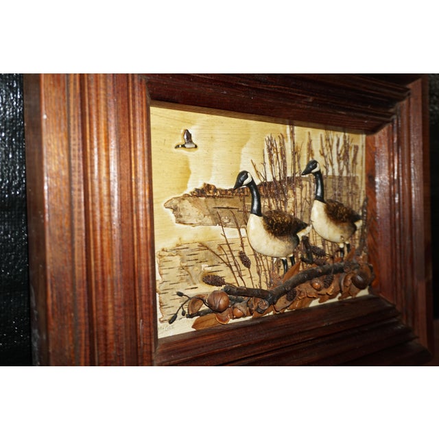 A charming handcrafted wildlife diorama featuring two beautifully detailed Canada geese surrounded by natural woodland...